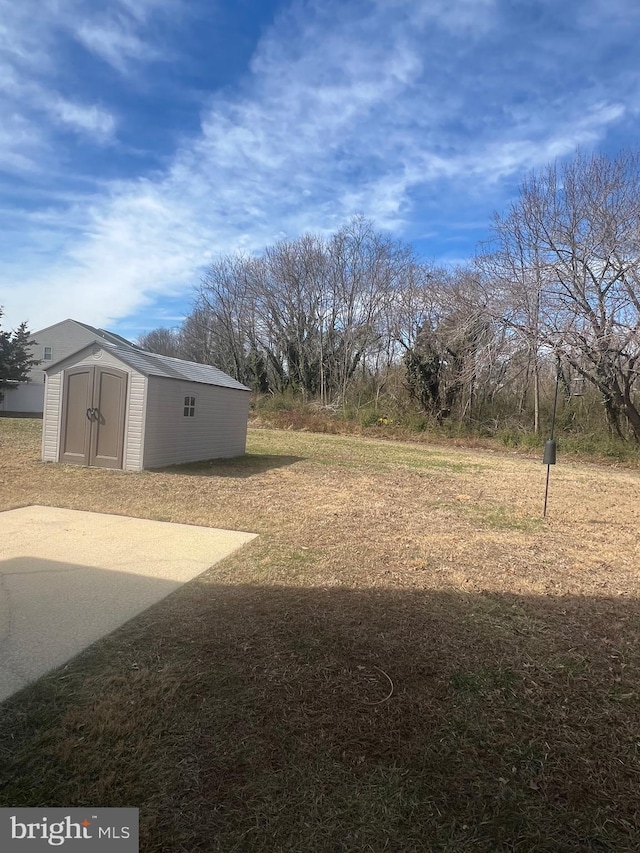 view of yard featuring a storage shed and an outdoor structure