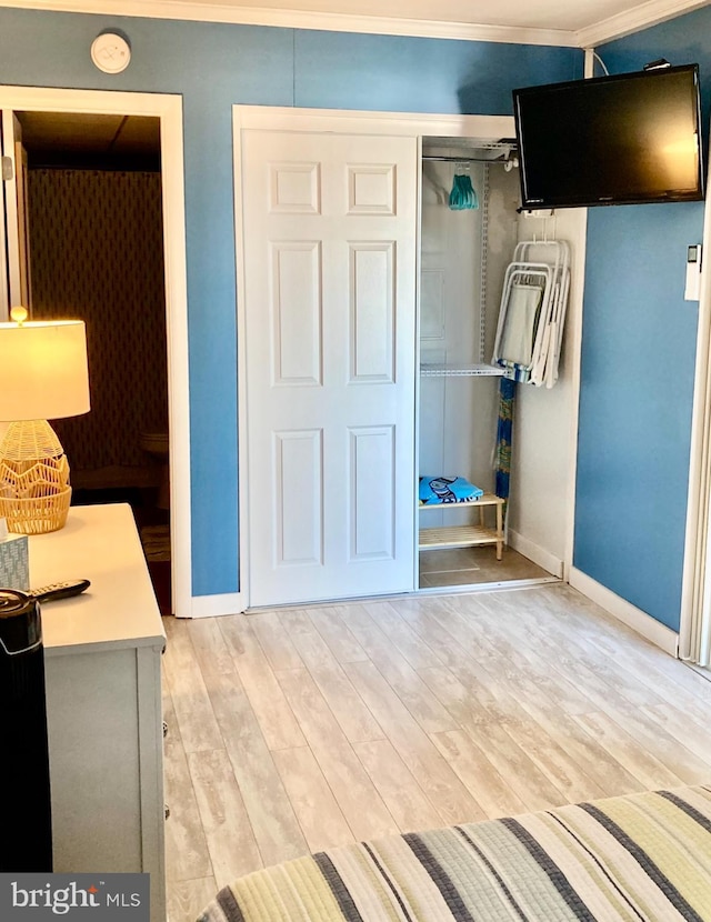 interior space featuring a closet, baseboards, and light wood finished floors