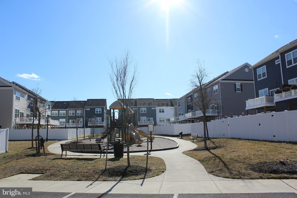 view of home's community with playground community, fence, and a residential view