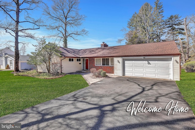 ranch-style home featuring a garage, a chimney, a front yard, and aphalt driveway