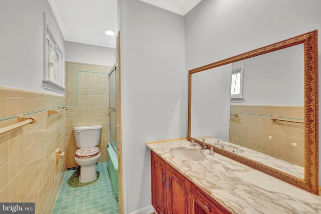 bathroom featuring tile patterned floors, toilet, tile walls, and vanity