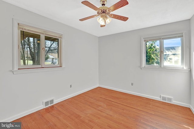 spare room with a wealth of natural light, visible vents, and light wood-style flooring