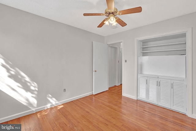 unfurnished bedroom with a closet, baseboards, ceiling fan, and light wood finished floors