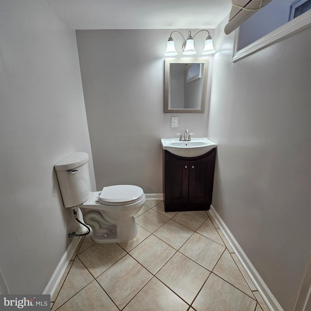 bathroom featuring vanity, tile patterned floors, toilet, and baseboards