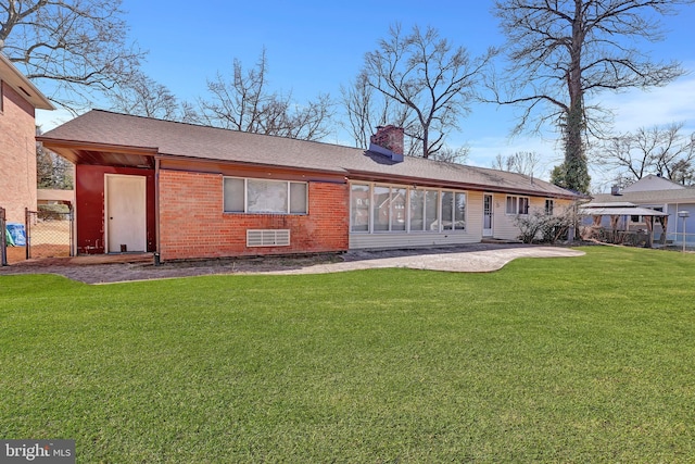 back of house featuring fence, a gazebo, a yard, brick siding, and a chimney