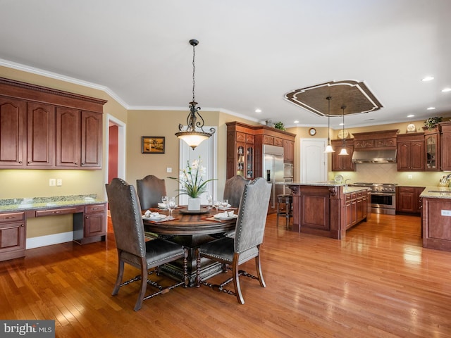 dining room with recessed lighting, wood finished floors, and ornamental molding