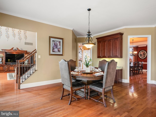 dining area with a notable chandelier, stairs, light wood-type flooring, and baseboards