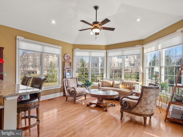 sunroom featuring visible vents, lofted ceiling, and ceiling fan