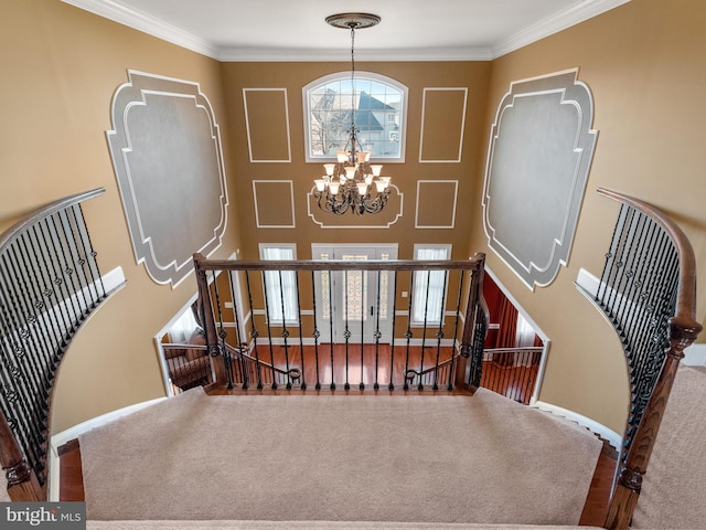 foyer entrance featuring a chandelier, crown molding, and baseboards