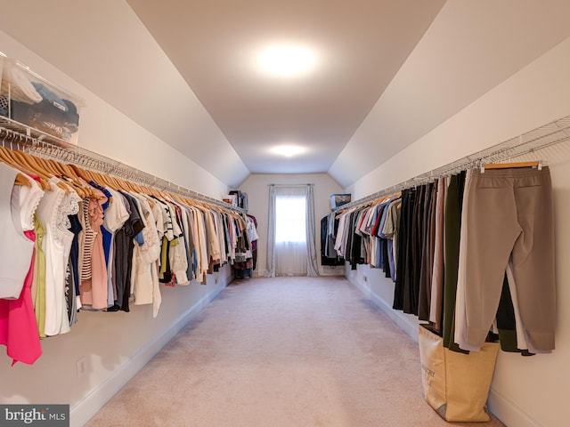 walk in closet featuring light colored carpet and vaulted ceiling