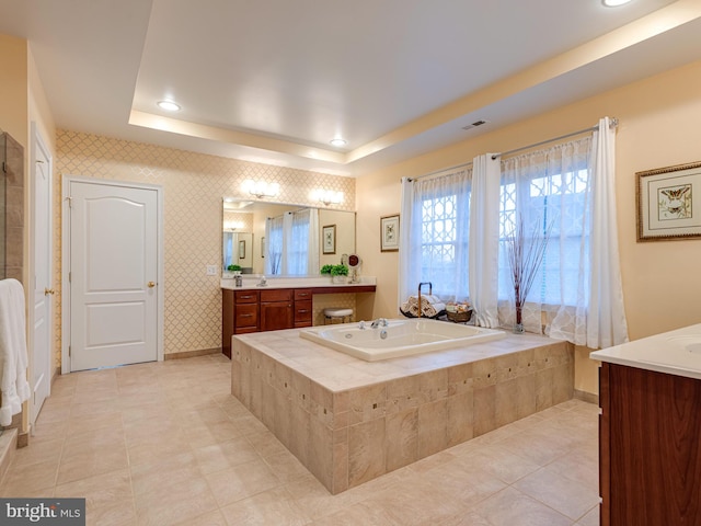 full bathroom featuring wallpapered walls, baseboards, a garden tub, vanity, and a raised ceiling