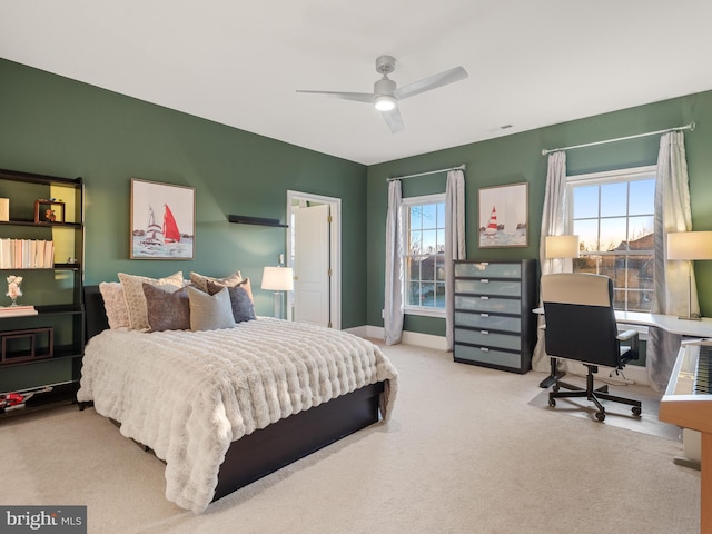 carpeted bedroom featuring baseboards, multiple windows, and a ceiling fan