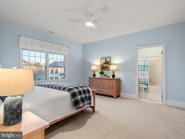 bedroom featuring visible vents, light colored carpet, ensuite bath, and baseboards