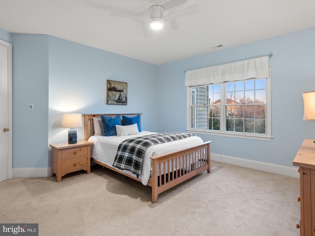 bedroom with ceiling fan, visible vents, baseboards, and light carpet