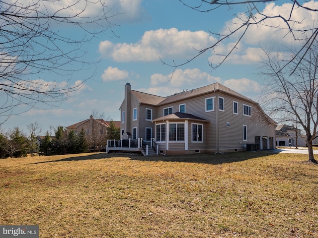 rear view of house featuring central air condition unit, a deck, a yard, a garage, and a chimney