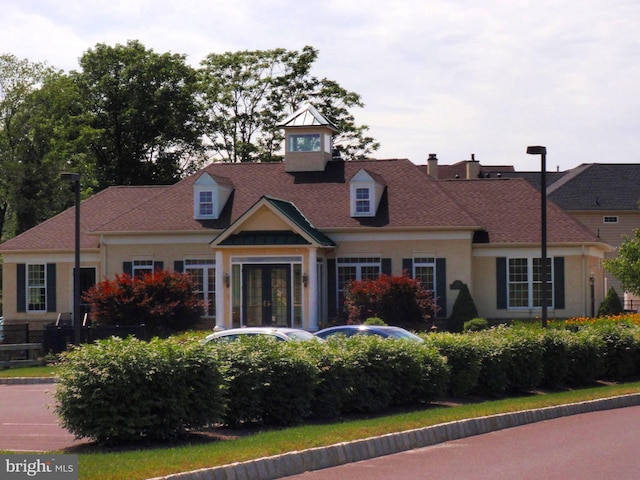 view of front of house with stucco siding and french doors