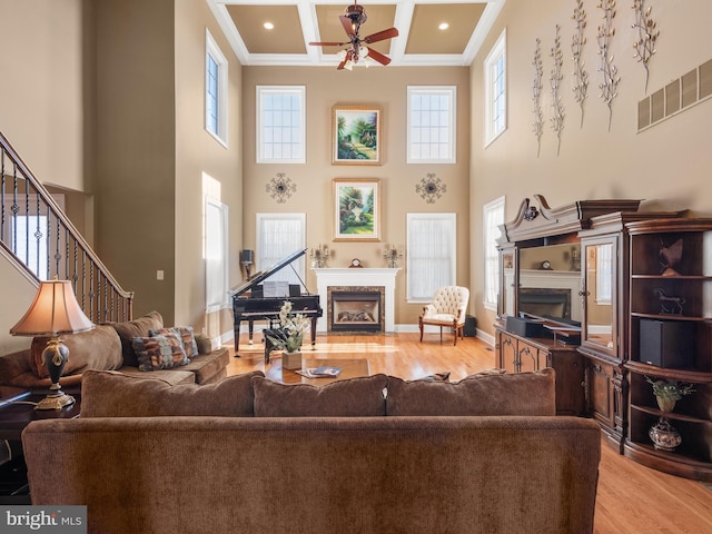 living room featuring visible vents, a fireplace, coffered ceiling, and wood finished floors