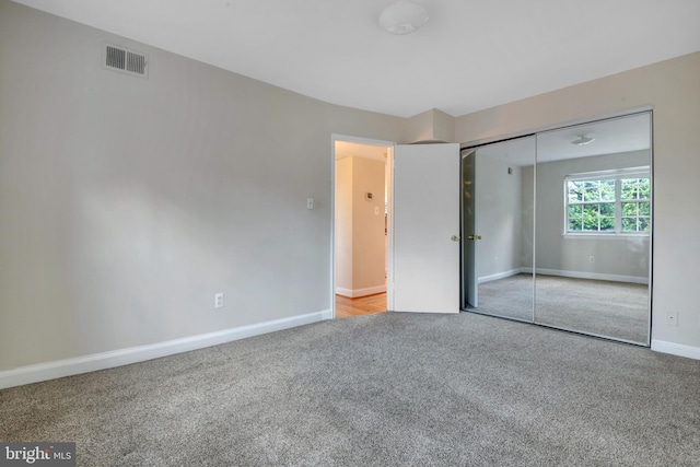 unfurnished bedroom featuring a closet, visible vents, carpet flooring, and baseboards