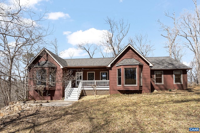 single story home featuring covered porch, a front yard, and a shingled roof