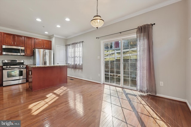 kitchen with crown molding, baseboards, light wood finished floors, and stainless steel appliances