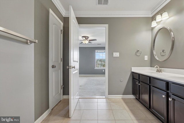 bathroom featuring visible vents, double vanity, a sink, tile patterned flooring, and crown molding