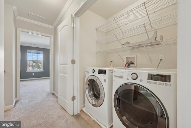 clothes washing area with baseboards, laundry area, washer and dryer, crown molding, and light colored carpet