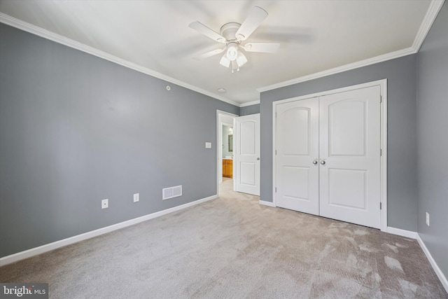 unfurnished bedroom featuring visible vents, ornamental molding, a closet, carpet flooring, and baseboards