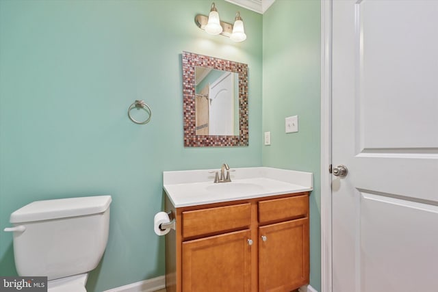 bathroom featuring toilet, vanity, and baseboards