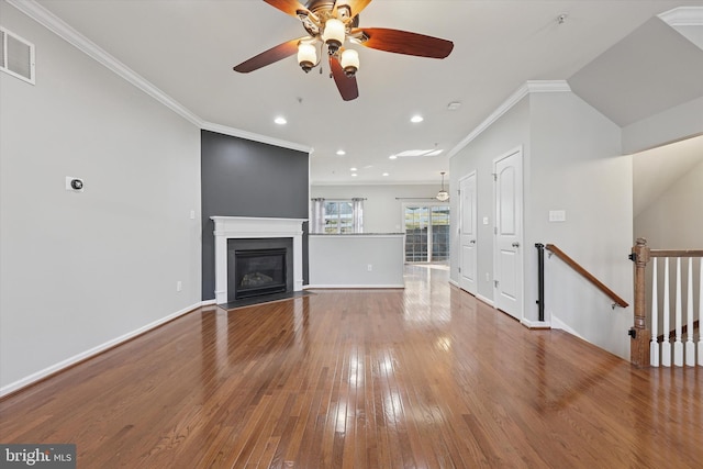 unfurnished living room featuring visible vents, crown molding, baseboards, a fireplace with flush hearth, and hardwood / wood-style floors