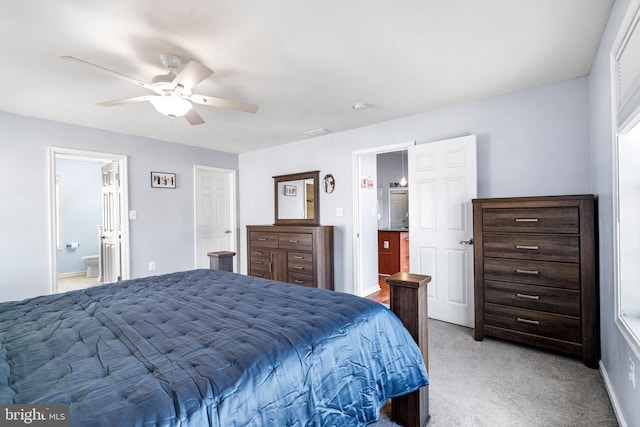 bedroom with light carpet, visible vents, ensuite bathroom, and ceiling fan