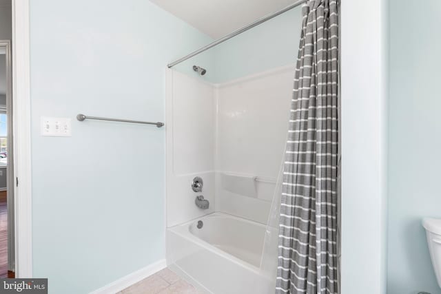 bathroom with tile patterned floors, toilet, and shower / tub combo with curtain