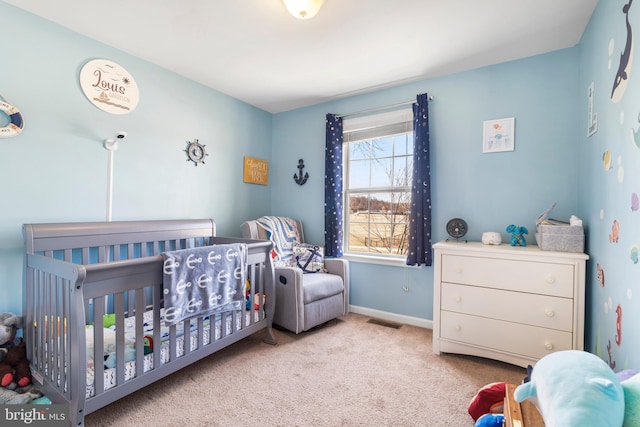 carpeted bedroom featuring visible vents, baseboards, and a nursery area