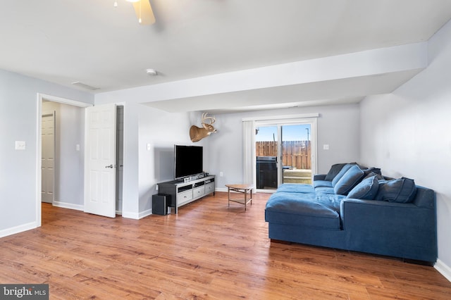 living room with light wood finished floors, visible vents, and baseboards