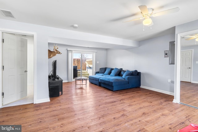 living area with visible vents, baseboards, light wood-style floors, and ceiling fan