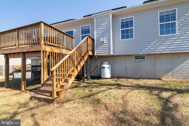 rear view of house with a yard, a deck, and stairway