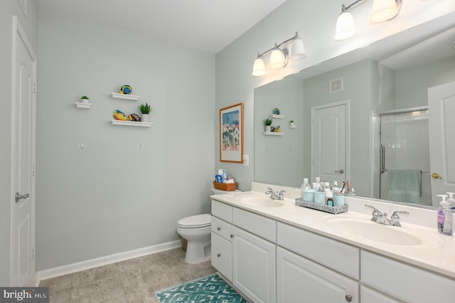 full bath featuring double vanity, a stall shower, baseboards, and a sink