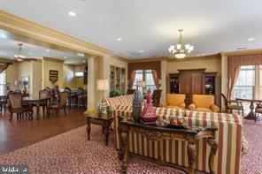 living room featuring crown molding, a notable chandelier, wood finished floors, and recessed lighting