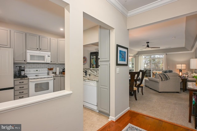 kitchen with white appliances, a ceiling fan, decorative backsplash, crown molding, and light wood-type flooring