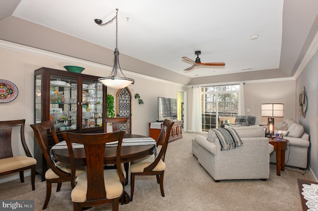 dining room with visible vents, a ceiling fan, crown molding, a raised ceiling, and light colored carpet