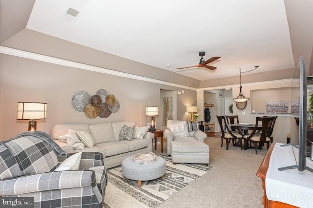 carpeted living area with visible vents and a ceiling fan