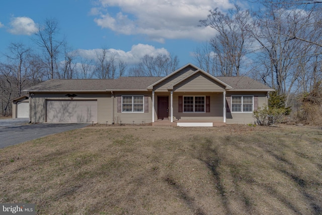 single story home with a front lawn, an attached garage, and driveway