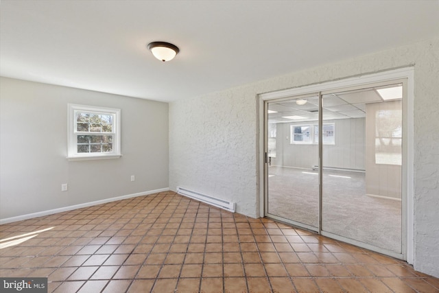 unfurnished room with a textured wall, baseboards, and baseboard heating