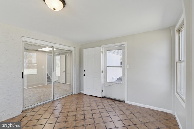 interior space with baseboards and a textured wall