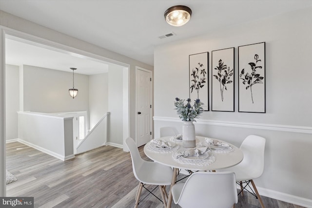 dining space with visible vents, baseboards, and wood finished floors