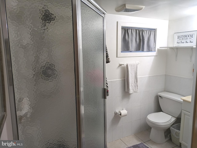 full bath featuring vanity, tile patterned flooring, a shower stall, tile walls, and toilet