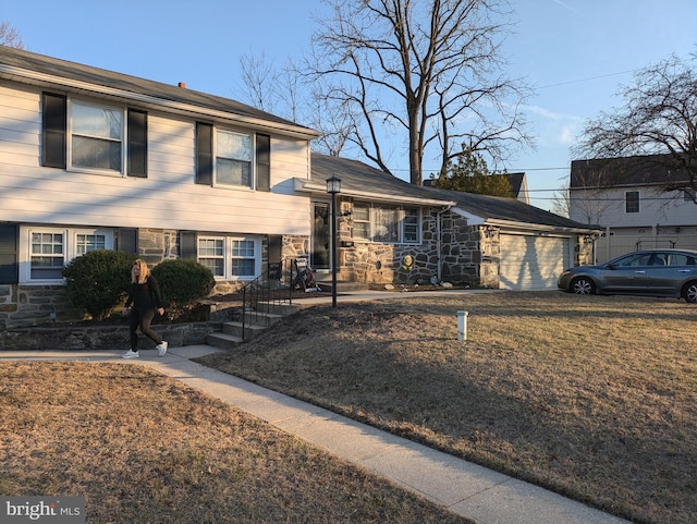 tri-level home with stone siding and a garage