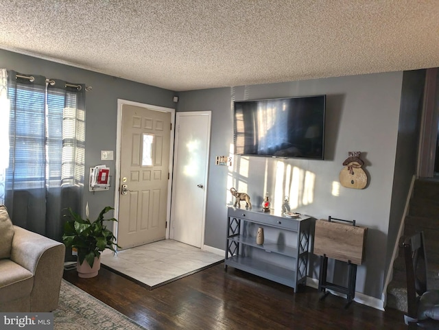 entryway with baseboards, a textured ceiling, and wood finished floors