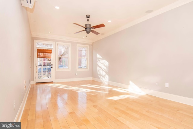 spare room featuring crown molding, light wood-style flooring, a ceiling fan, and baseboards