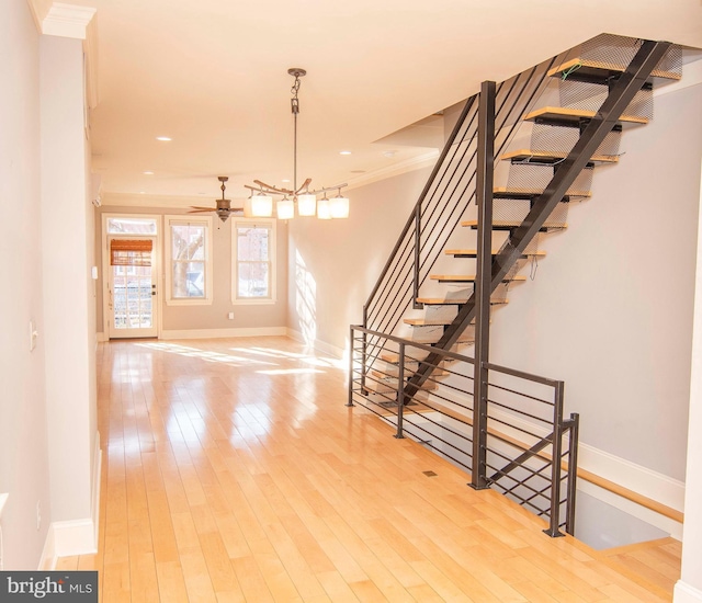 stairs with recessed lighting, crown molding, baseboards, and wood-type flooring