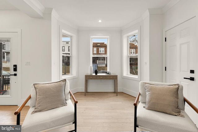 living area featuring recessed lighting, baseboards, crown molding, and light wood-style floors